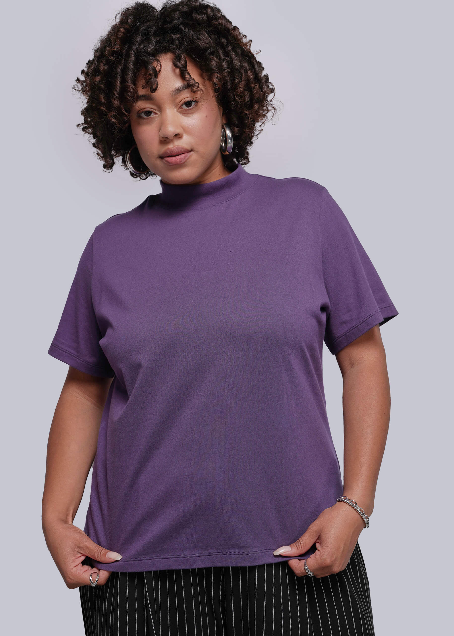 1X=Person wearing a purple t-shirt against a plain background