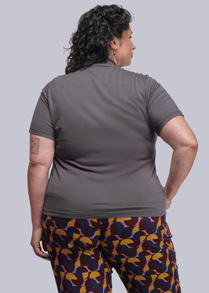1X=Person wearing a gray shirt and patterned pants on a plain background
