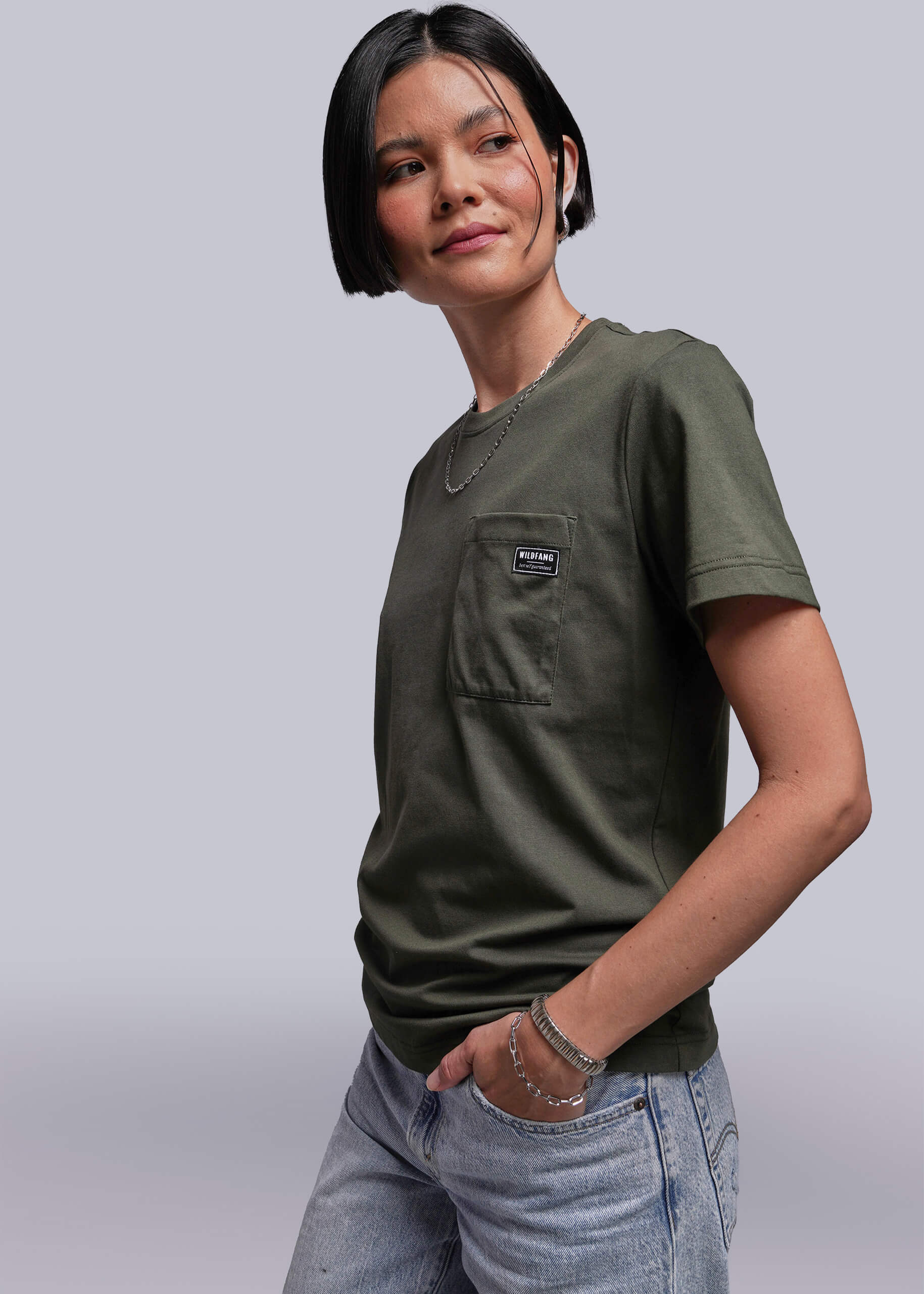 S=Person wearing a green t-shirt with a pocket on a plain background