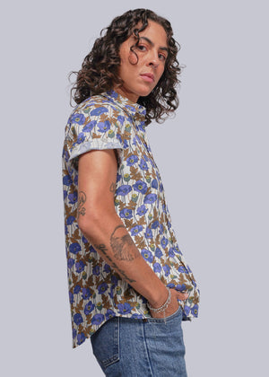 S=Person wearing a floral shirt and jeans against a plain background