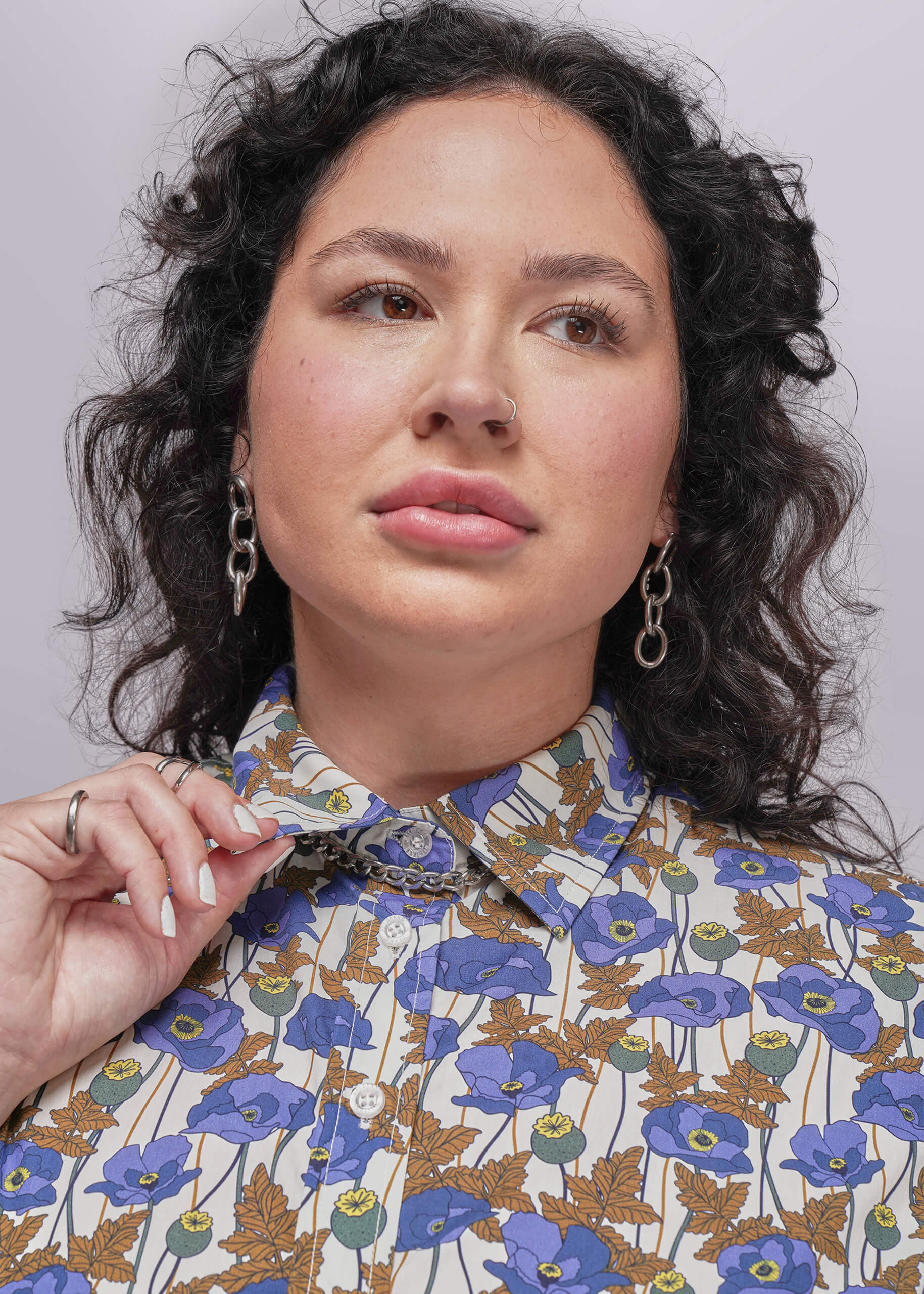 1X=Person wearing a floral patterned shirt against a plain background