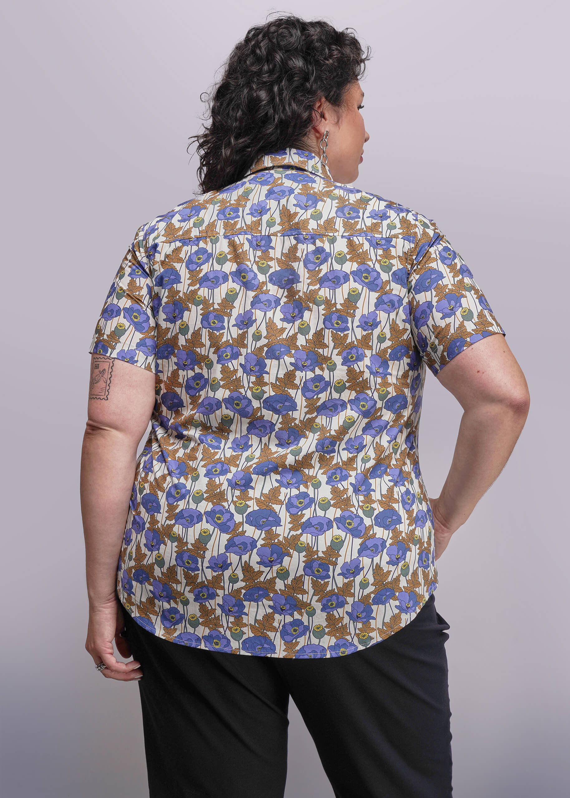 1X=Person wearing a floral patterned shirt with a plain background