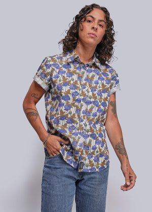 S=Person wearing a floral short-sleeve shirt and jeans against a plain background