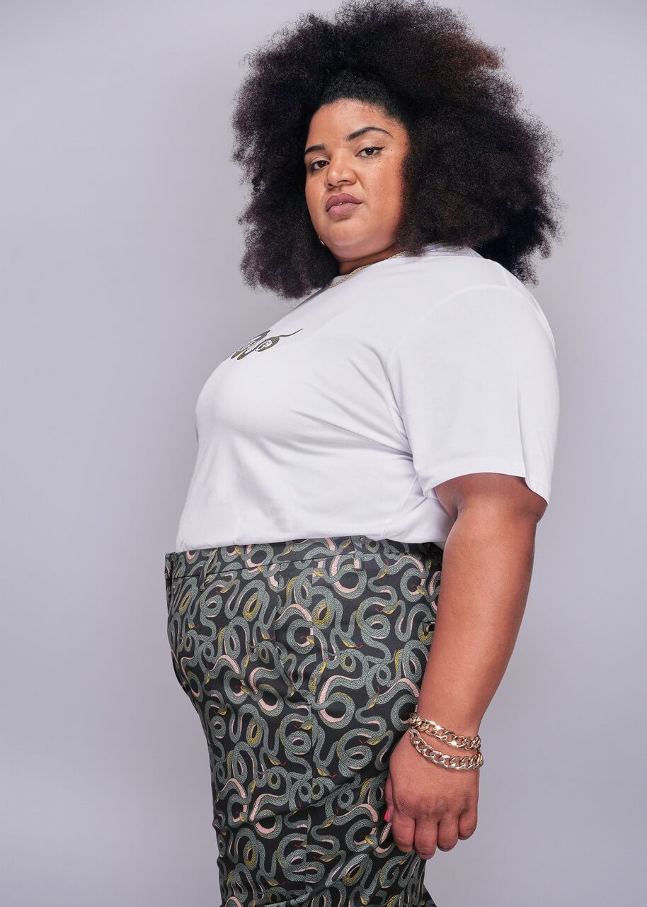 1X=Person wearing a white t-shirt and patterned pants on a plain background