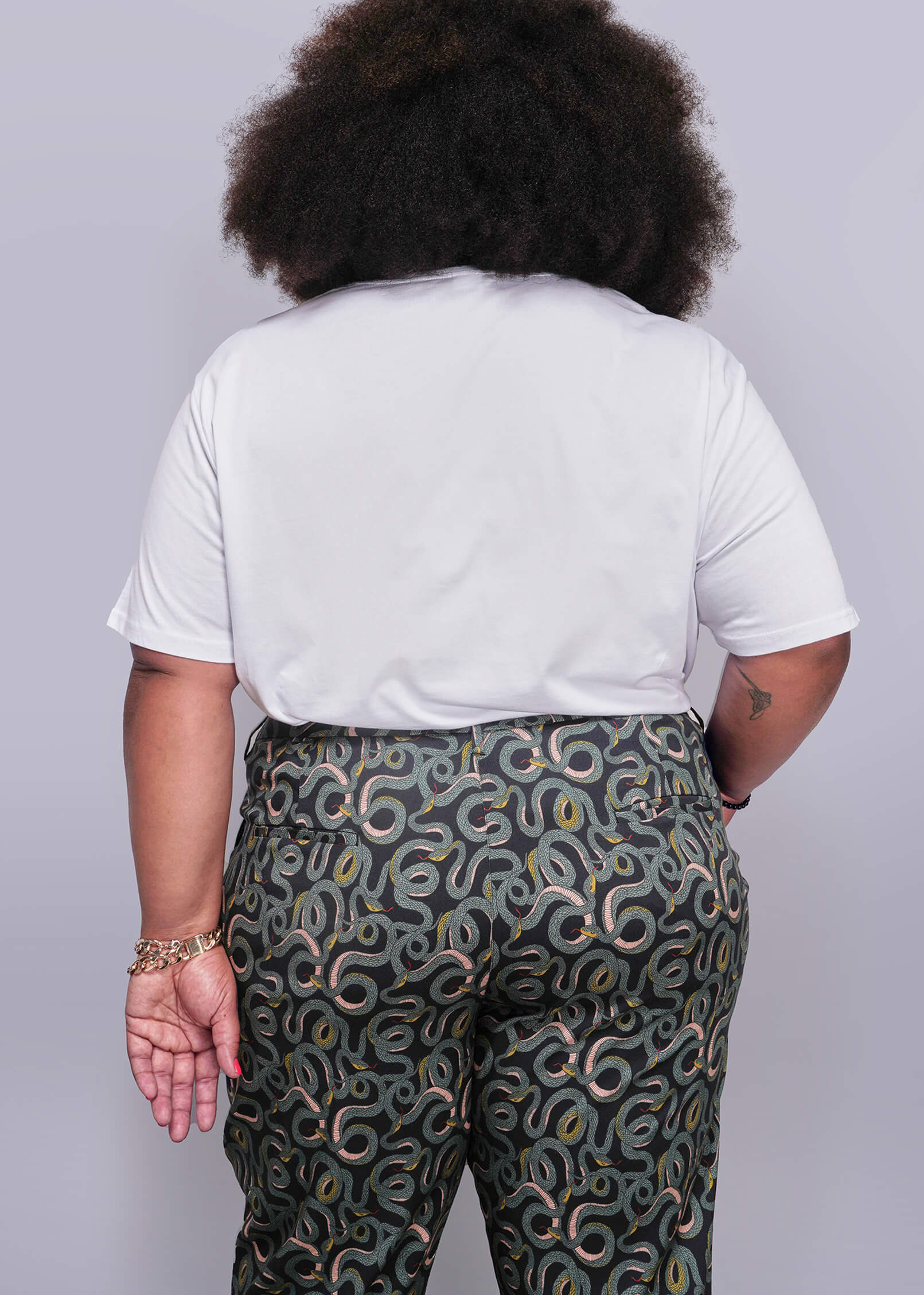 1X=Person wearing a white t-shirt and patterned pants on a plain background