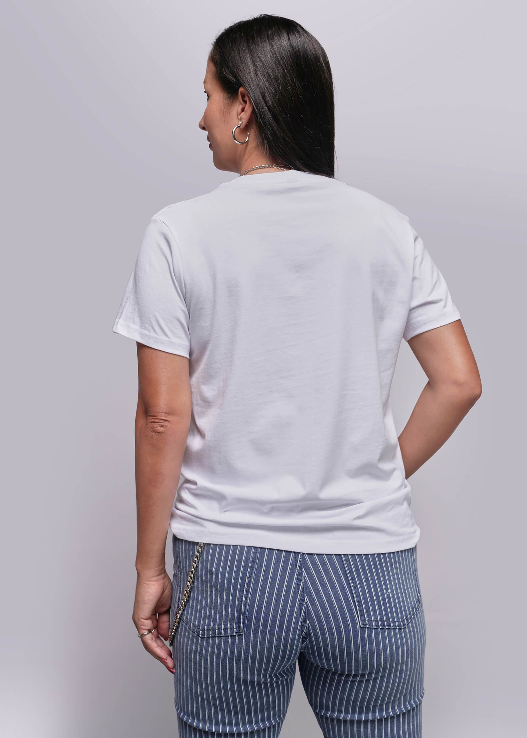 S=Person wearing a plain white t-shirt and striped pants on a light gray background