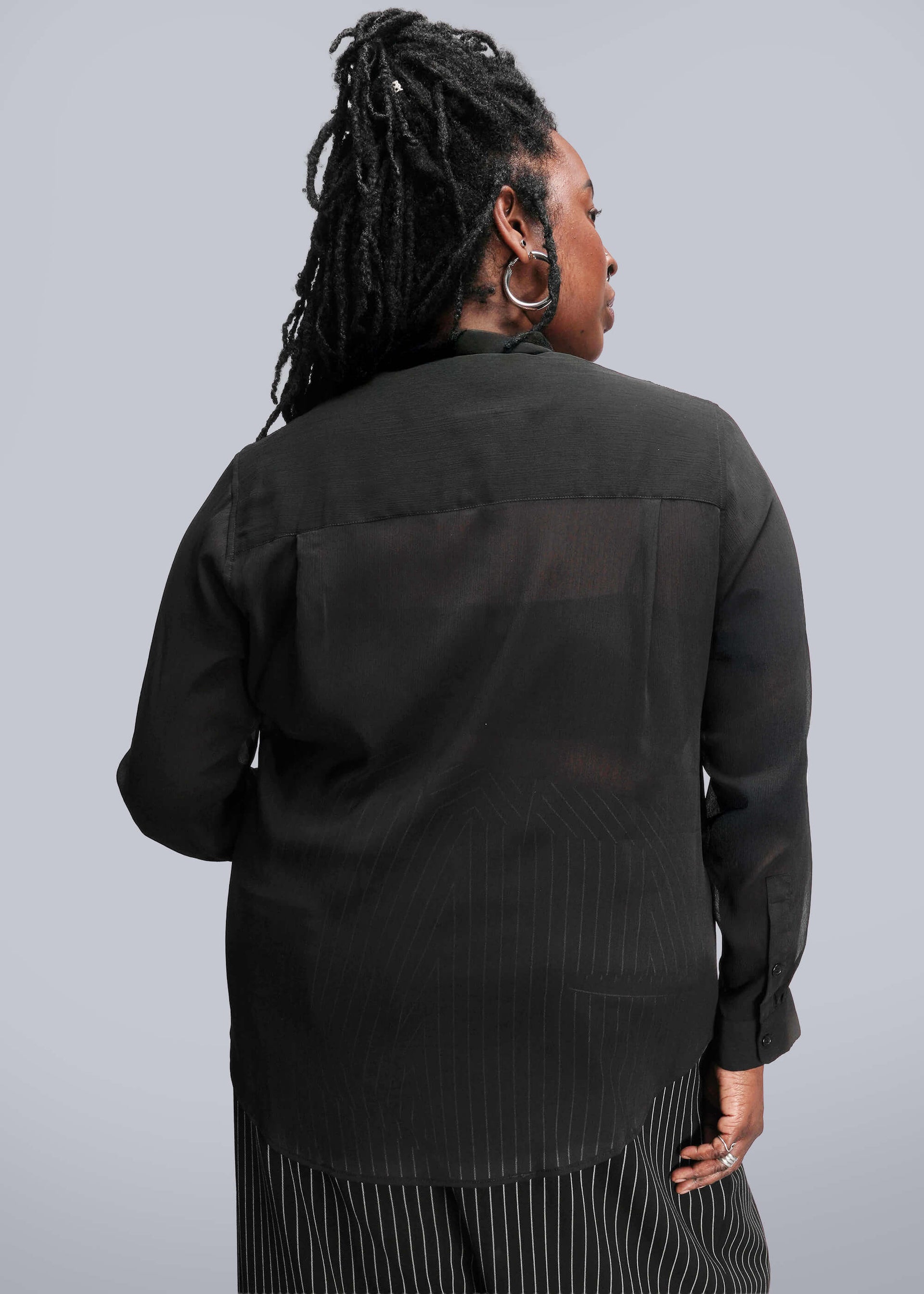1X=Person wearing a black jacket with a plain background