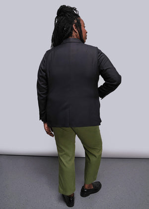 1X=Person wearing a black jacket and green pants standing against a white background