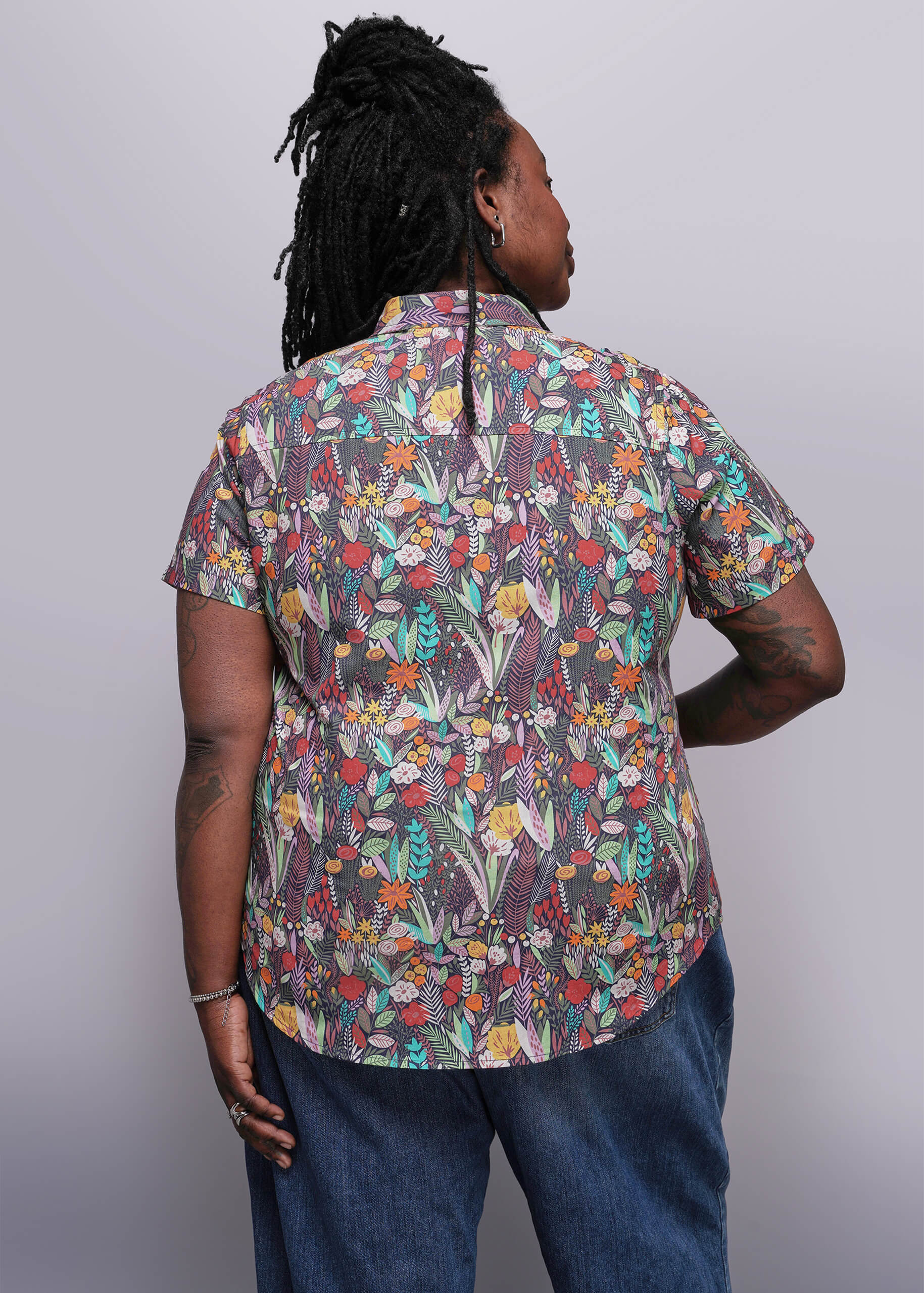 1X=Person wearing a colorful floral shirt against a plain background