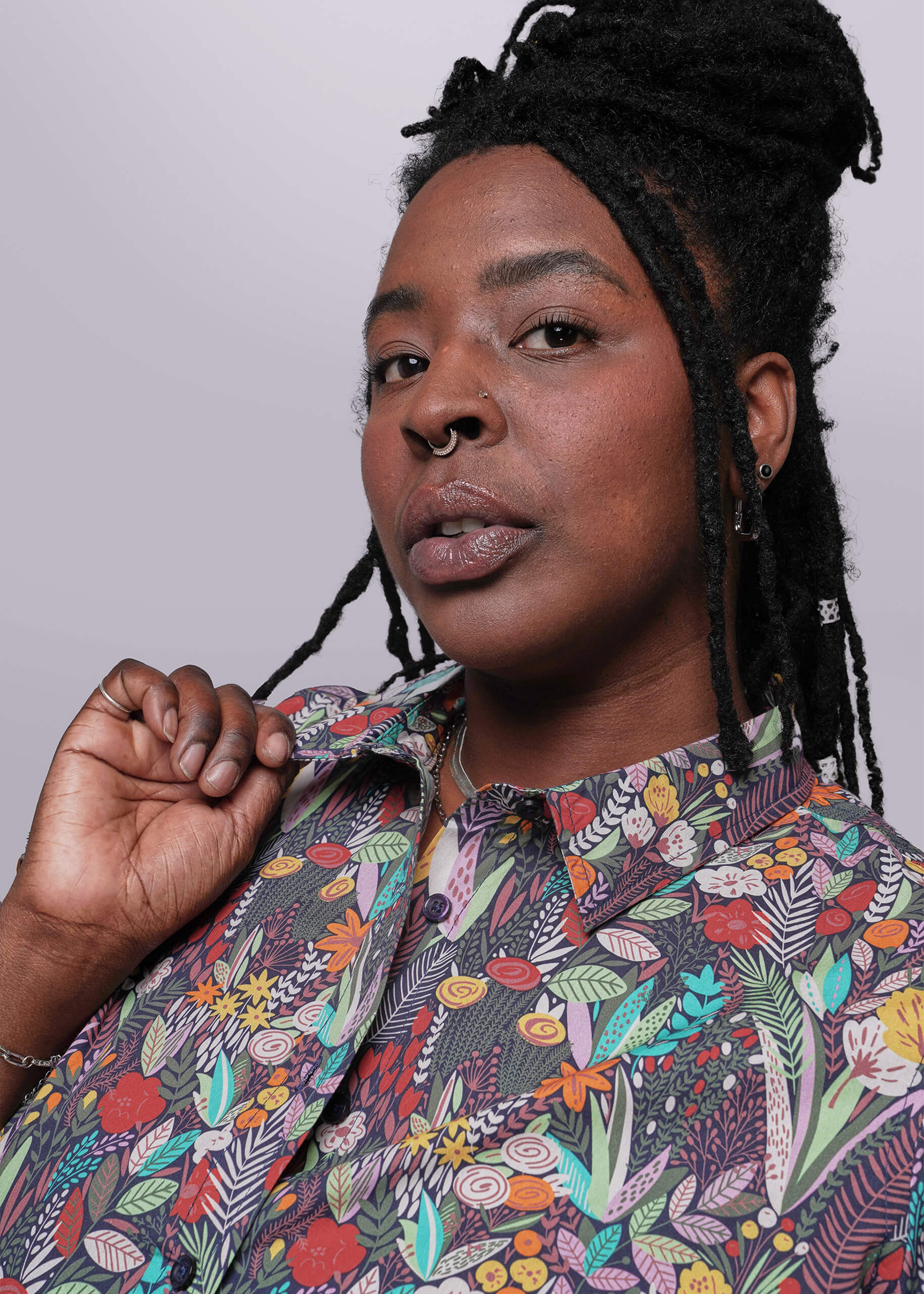 1X=Person wearing a colorful patterned shirt against a plain background