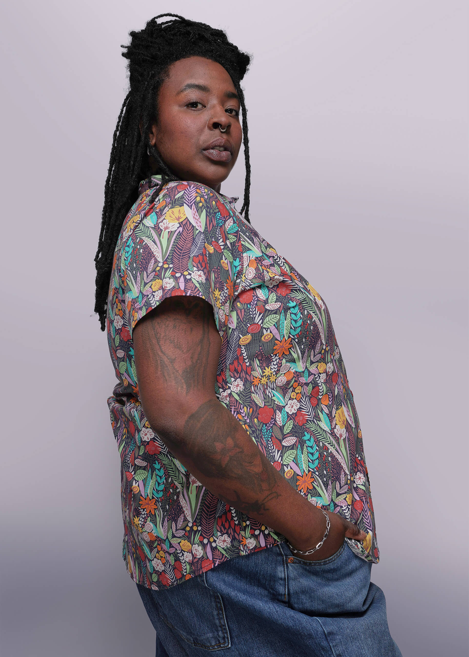 1X=Person wearing a colorful floral shirt against a plain background