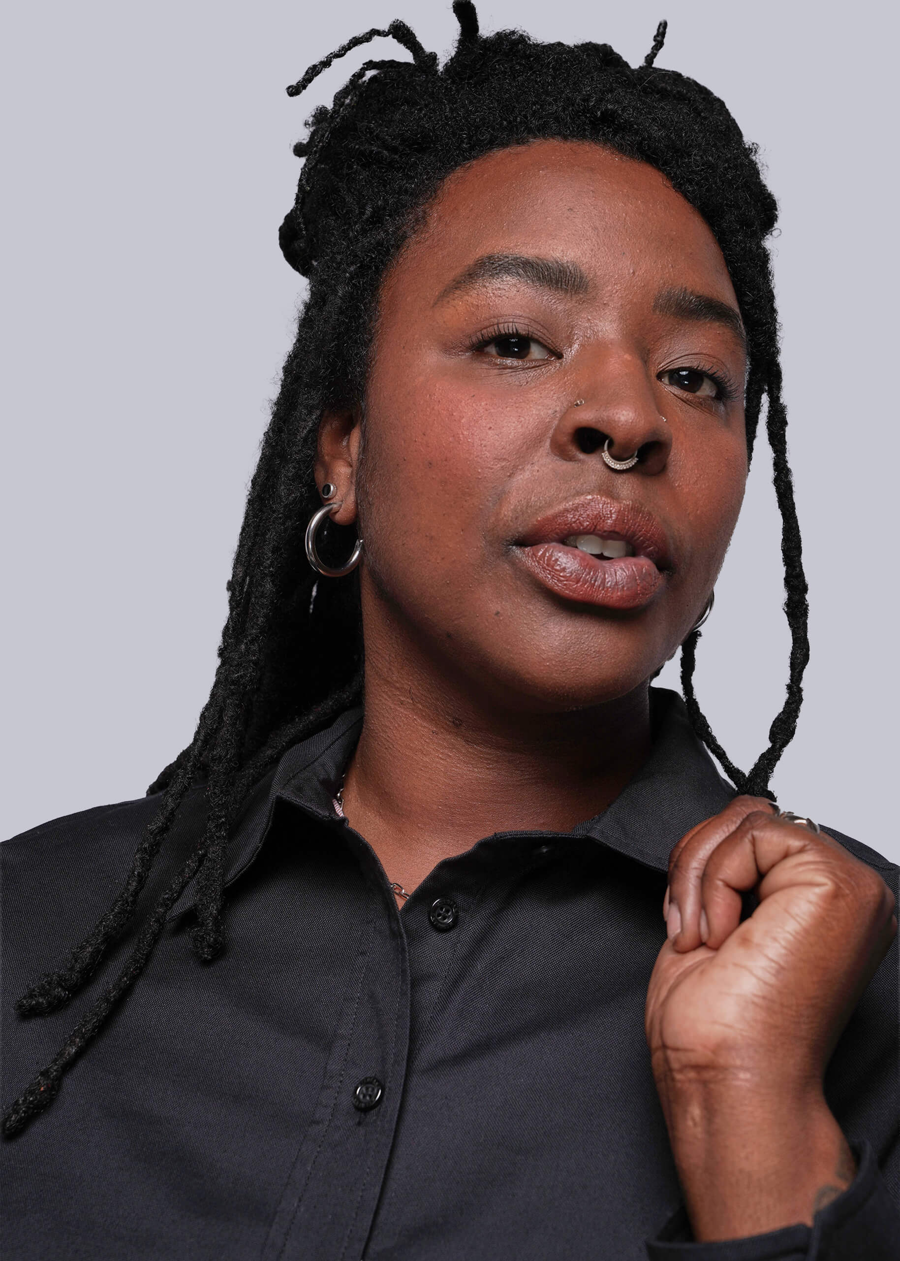 1X=Person wearing a black shirt against a plain background