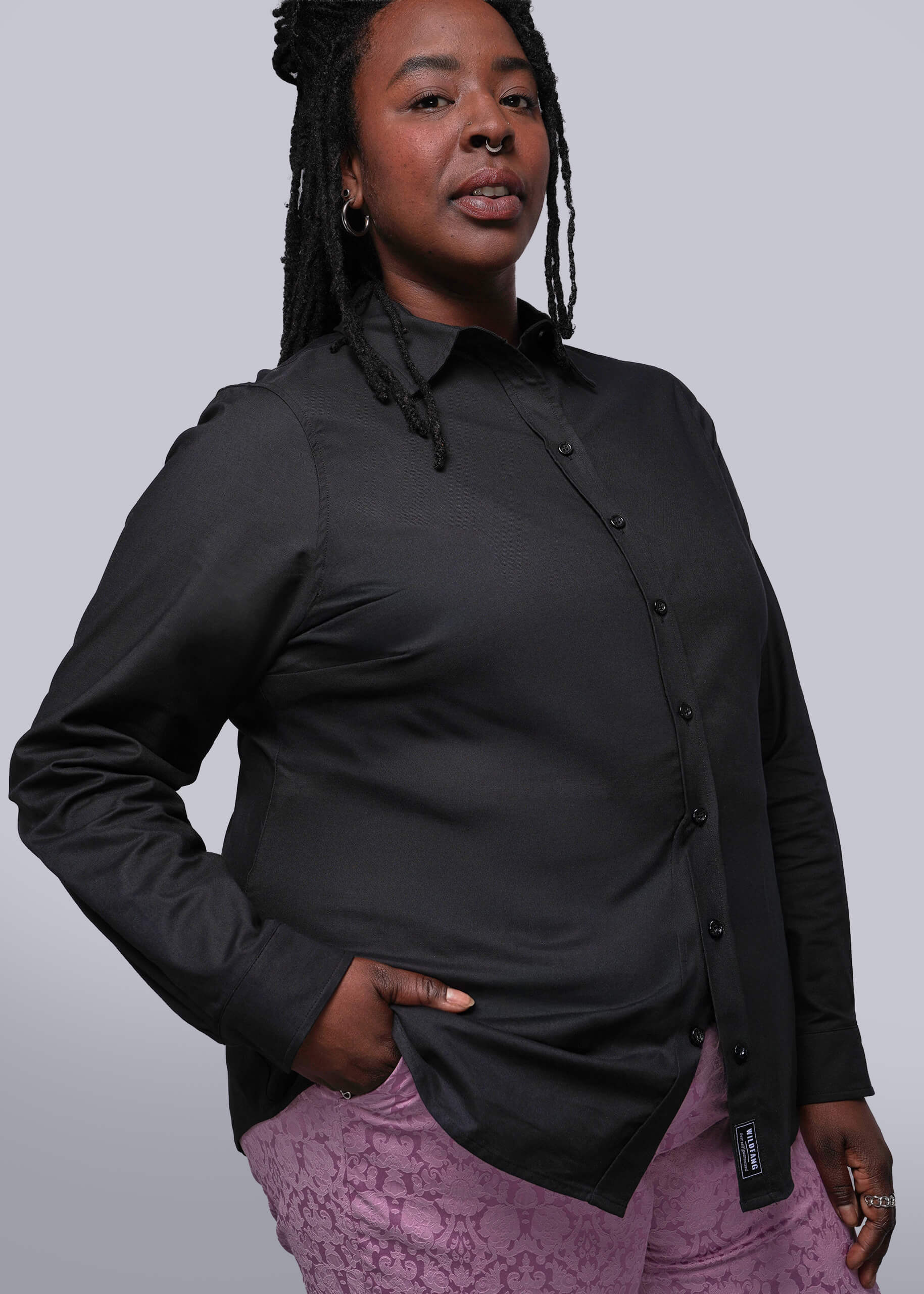 1X=Person wearing a black shirt with a unique collar design against a plain background