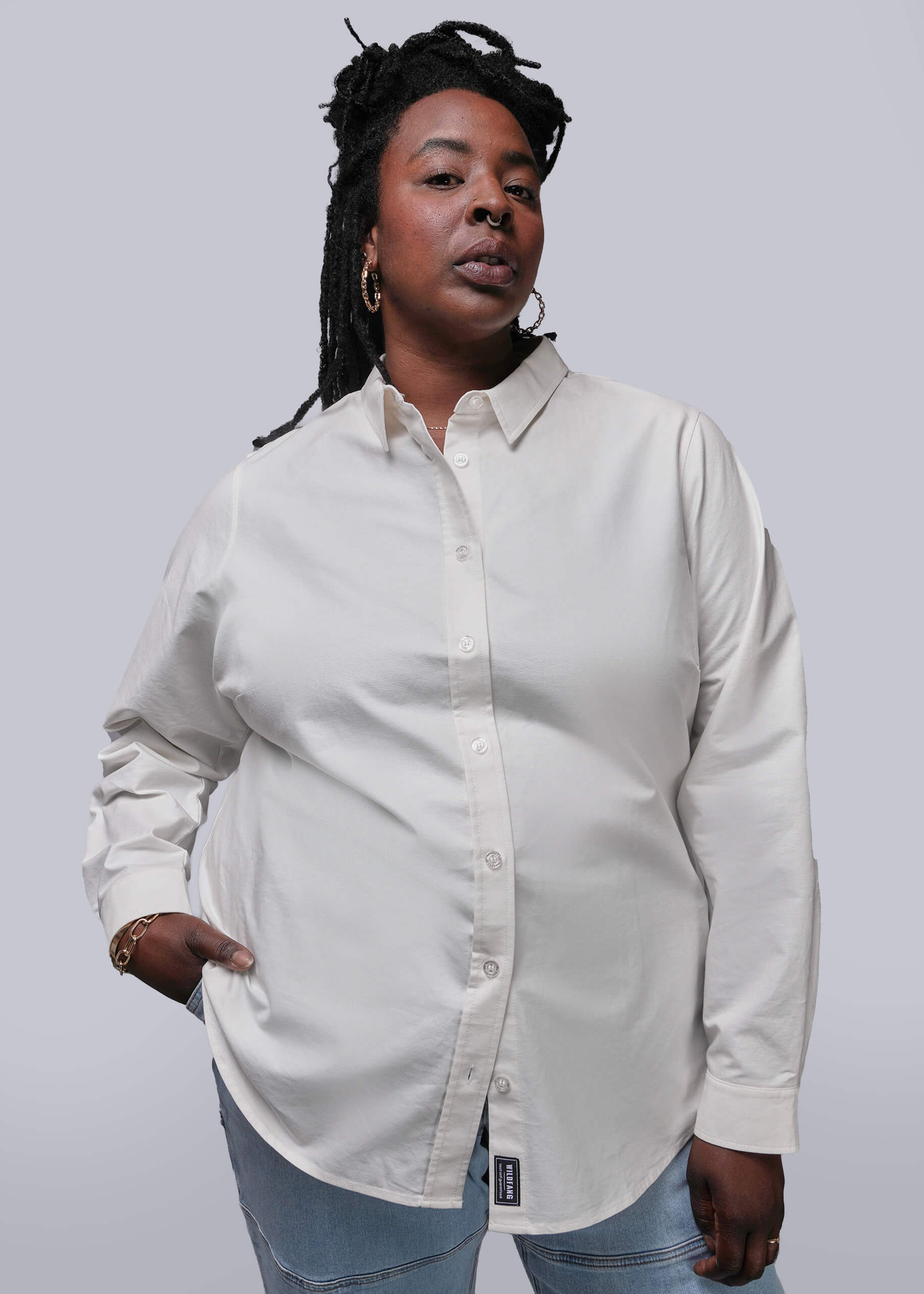 1X=Person wearing a white long sleeve button-up shirt against a plain background