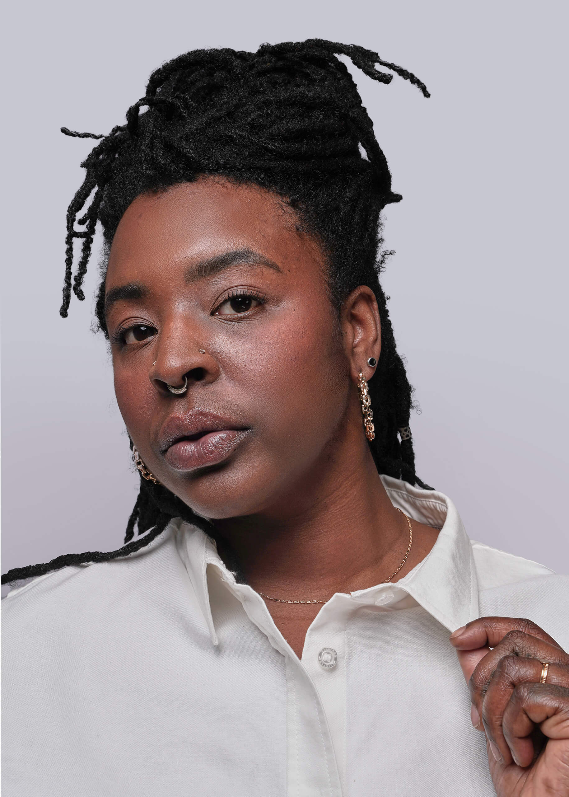 1X=Close up of Person wearing a white shirt against a plain background