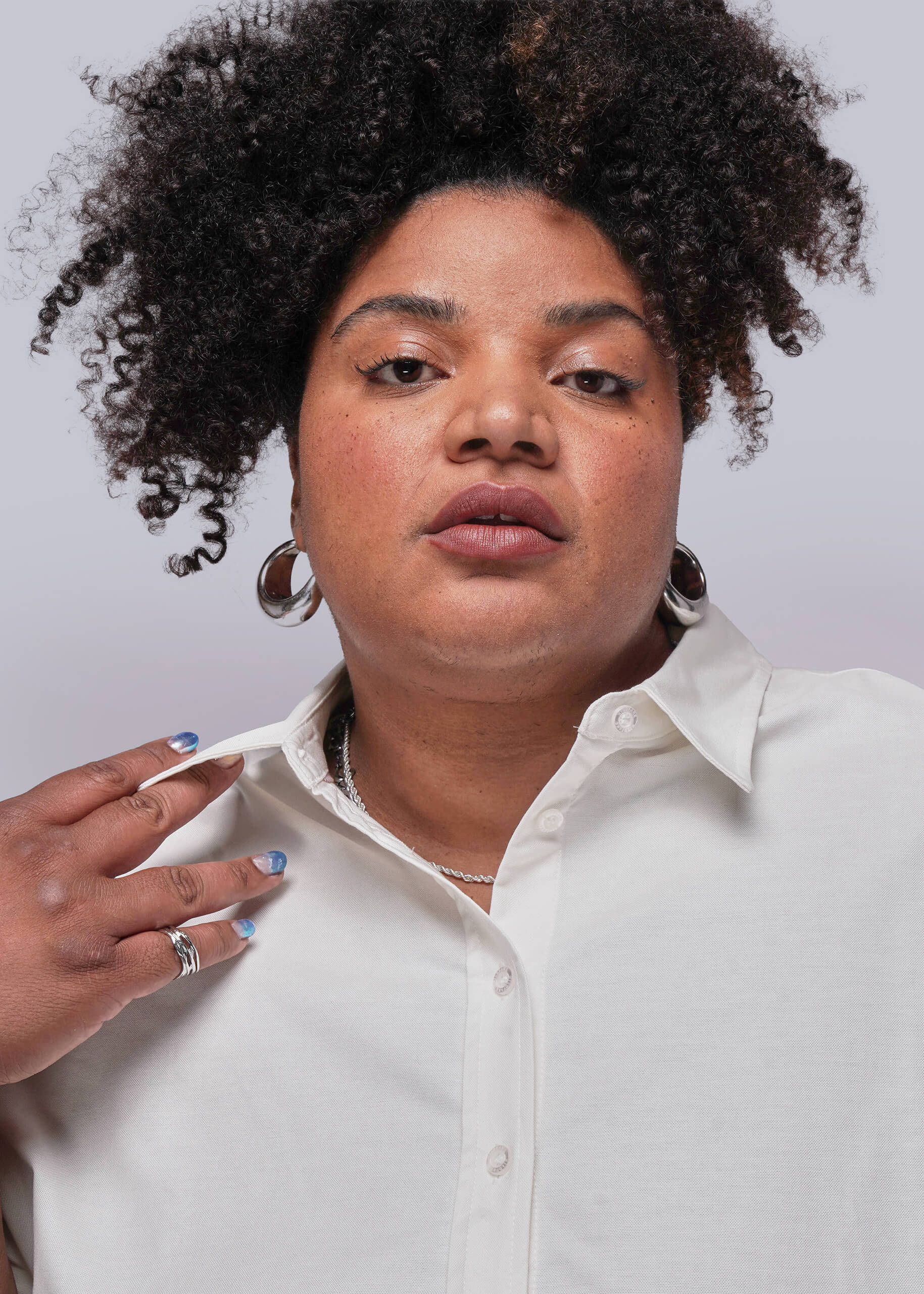 1X=Person wearing a white shirt with a plain background