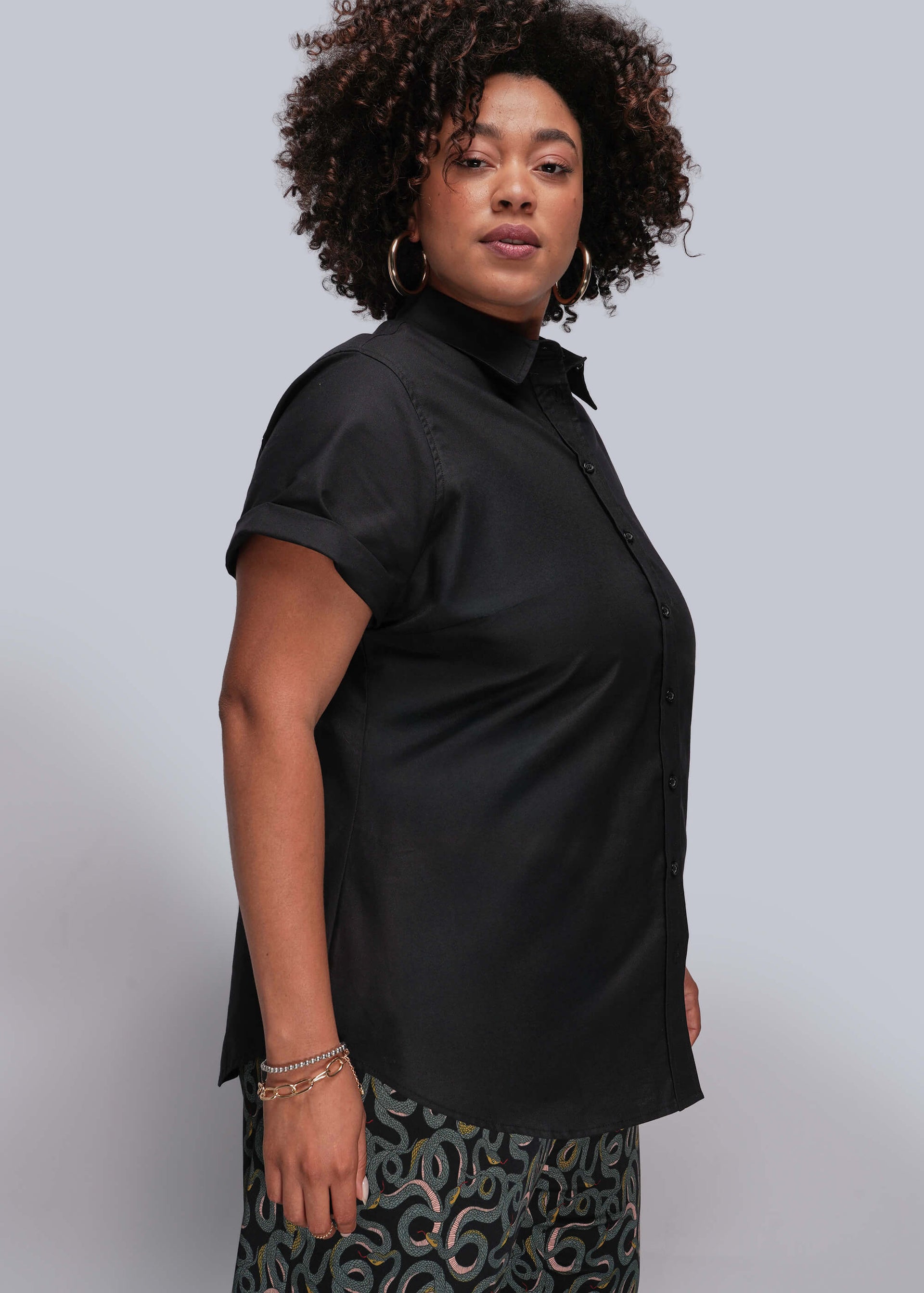 1X=Person wearing a black short-sleeve shirt against a plain background