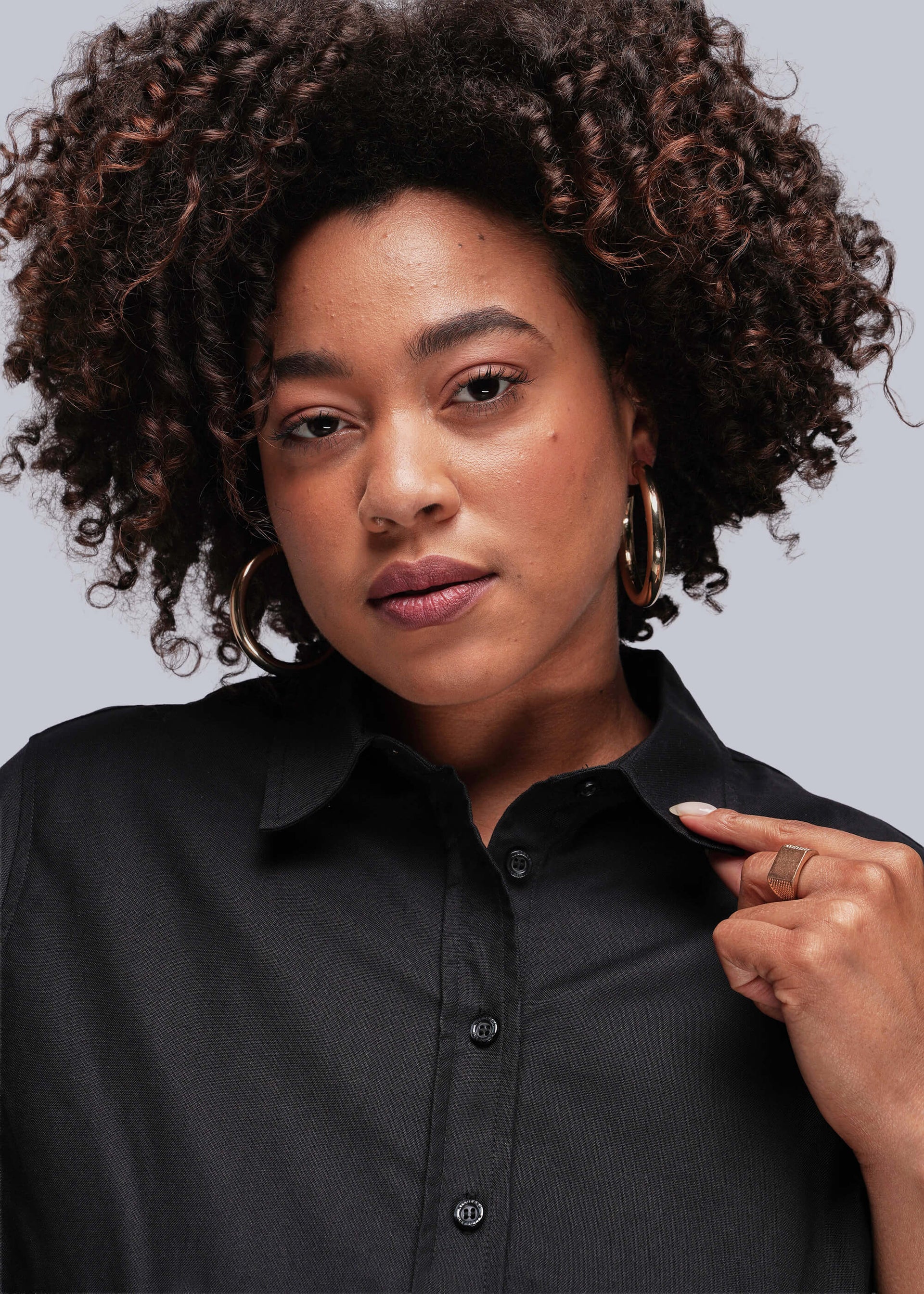 1X=Person wearing a black shirt against a gray background