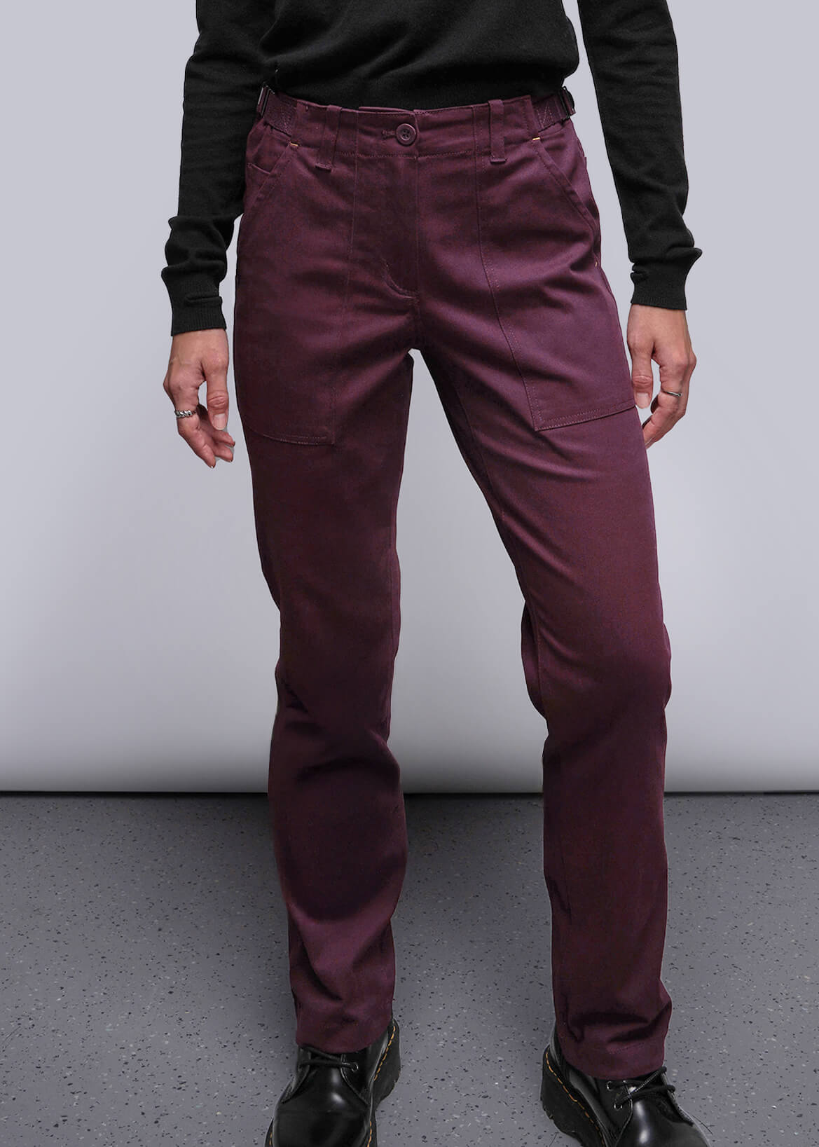 S=Person wearing maroon pants and black shoes on a plain background
