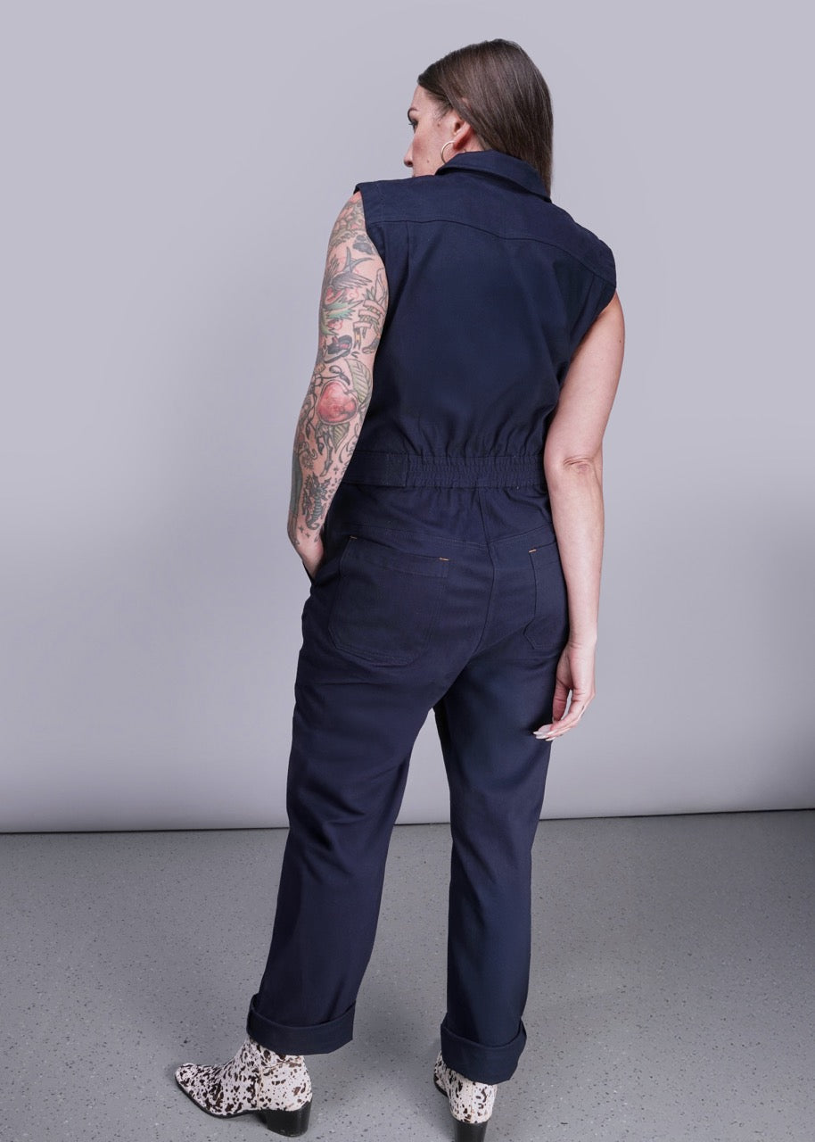 S=Person wearing a navy blue sleeveless jumpsuit against a plain background