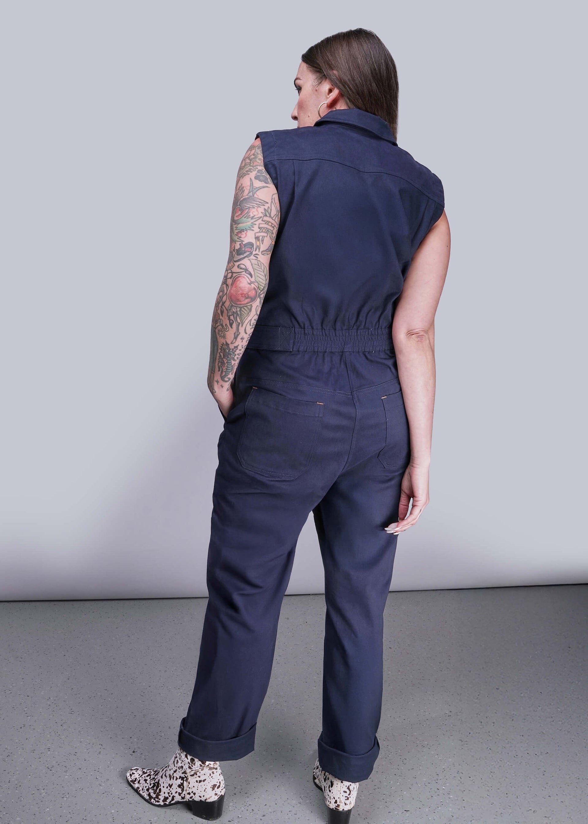 S=Person wearing a navy blue sleeveless jumpsuit against a plain background