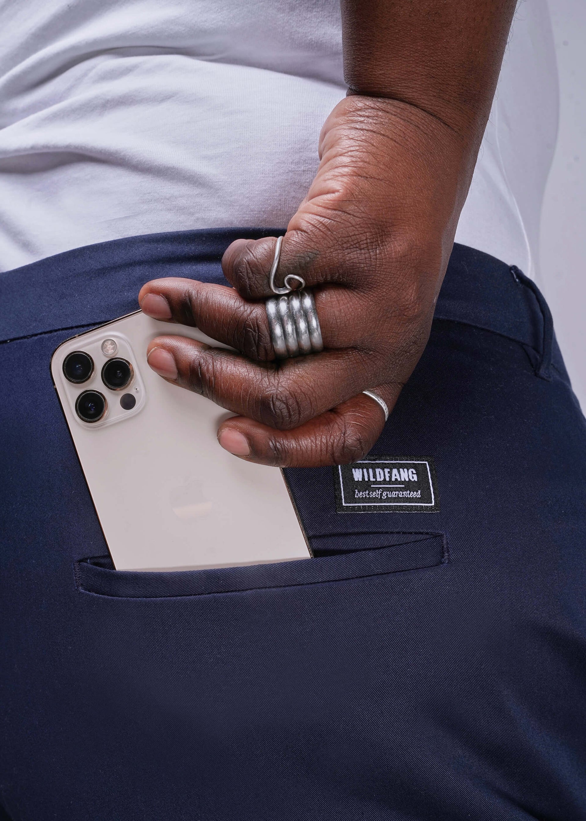 1X=Person holding a phone in a navy pocket with a visible brand label.