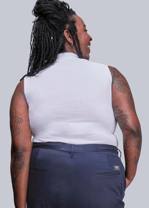 1X=Person wearing a white sleeveless top and navy pants against a plain background