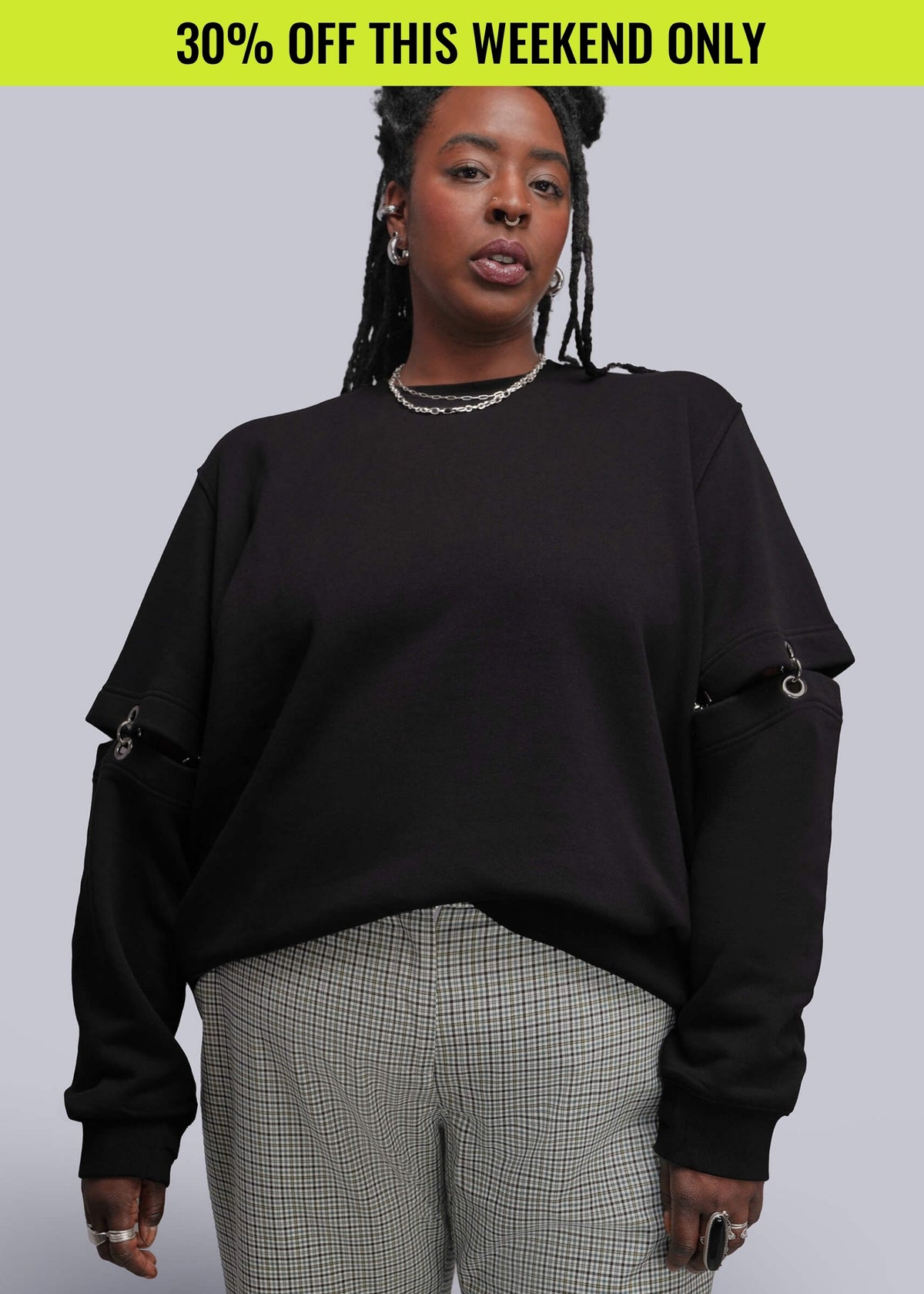 Person wearing black sweatshirt standing in front of gray background. Promotional banner on top of image reads 30% OFF THIS WEEKEND ONLY