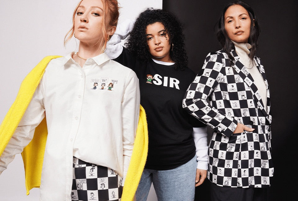 Three people stand together modeling pieces from the PEANUTS X WILDFANG collection. Background is black and white.