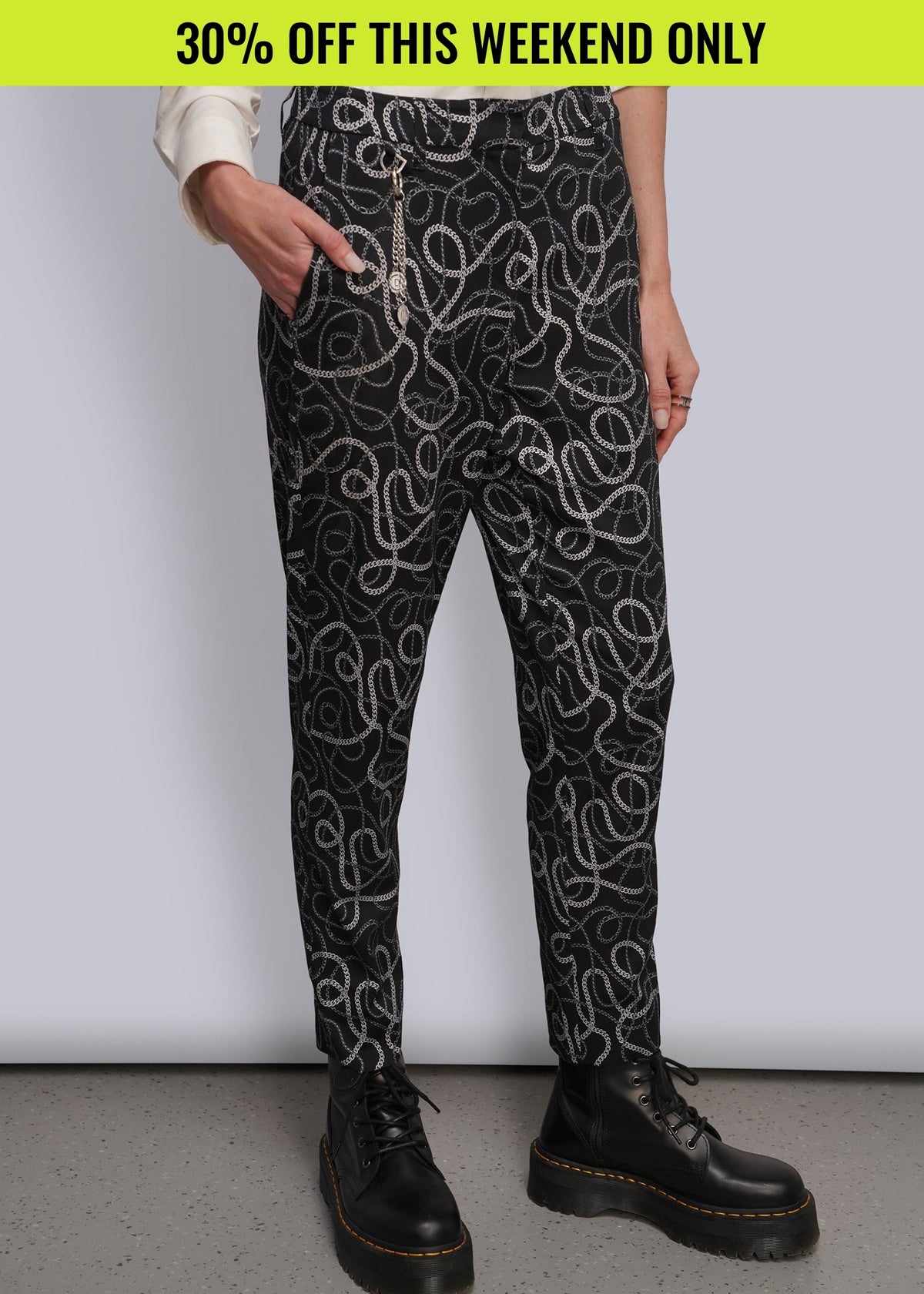 Pictured from waist down, model wears black printed suit pants with chain pattern. Promotional banner on top of image reads 30% OFF THIS WEEKEND ONLY