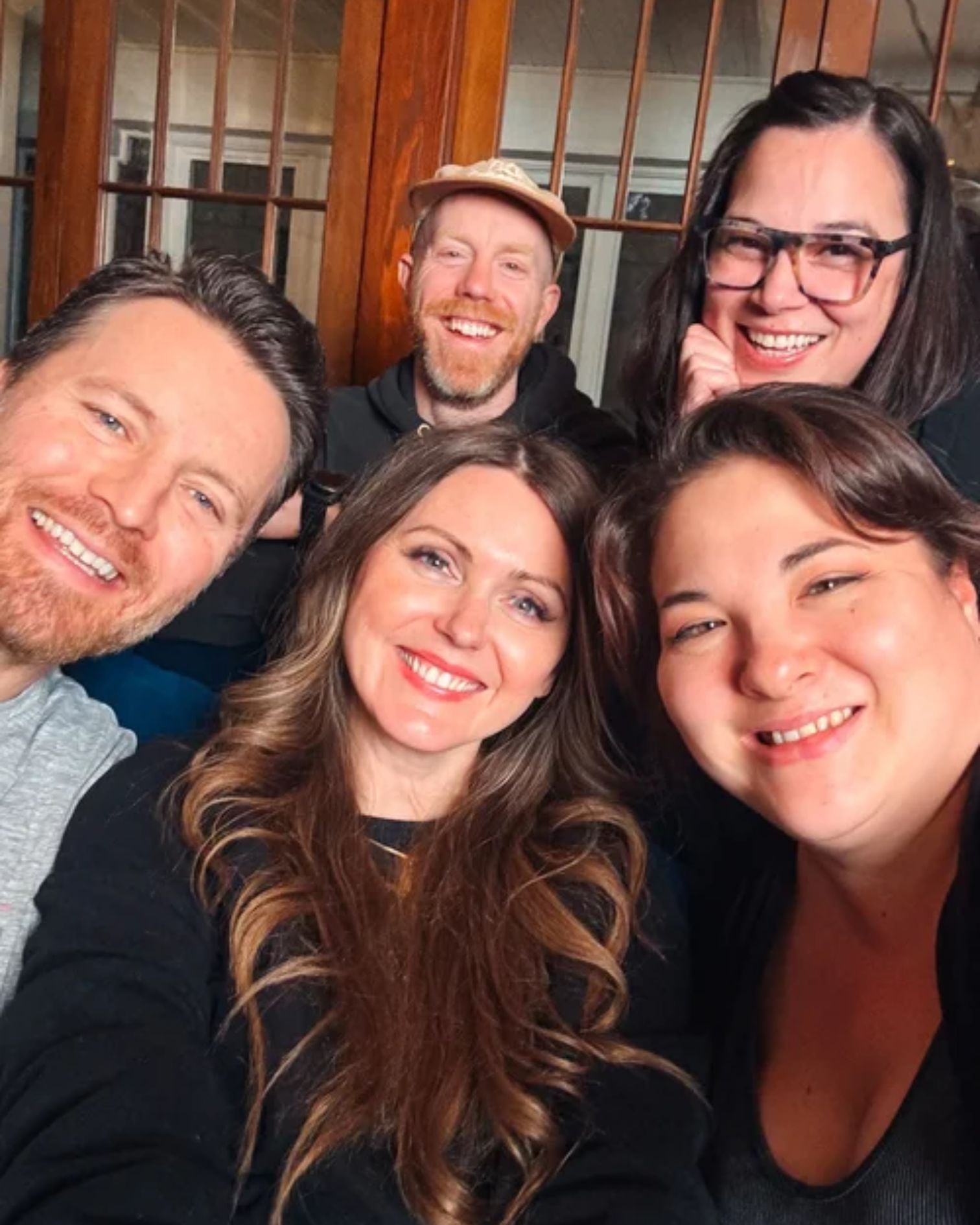Group of people smiling taking selfie.