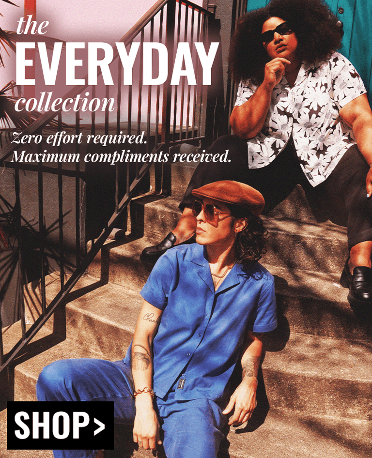 Two models sit on concrete staircase. Model on top of stairs wears The Everyday Camp Button Up in sketchy daisy and The Everyday Elastic Waist Pant in black, along with loafers and sunglasses.  Model at bottom wears the same button up in pant, but both in Oxford Blue, along with brown loafers and a white tank top underneath. Text over lay on left side of image reads "the everyday collection, zero effort required. maximum compliments received" A black button underneath reads SHOP.