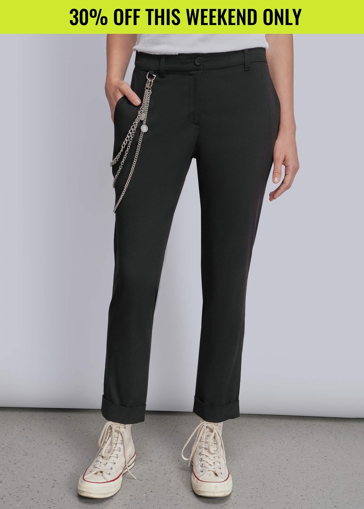 Pictured from waist down, model wears black trouser with wallet chain detail on side and white sneakers. Promotional banner on top of image reads 30% OFF THIS WEEKEND ONLY