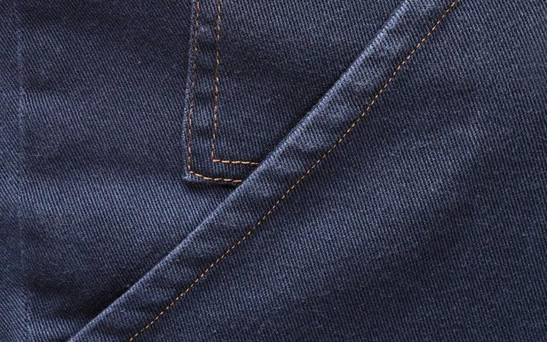Close up of seam detail on denim pant pocket