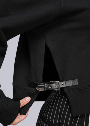 S=Close-up of a sweatshirt with buckle and pinstripe pants on a light gray background