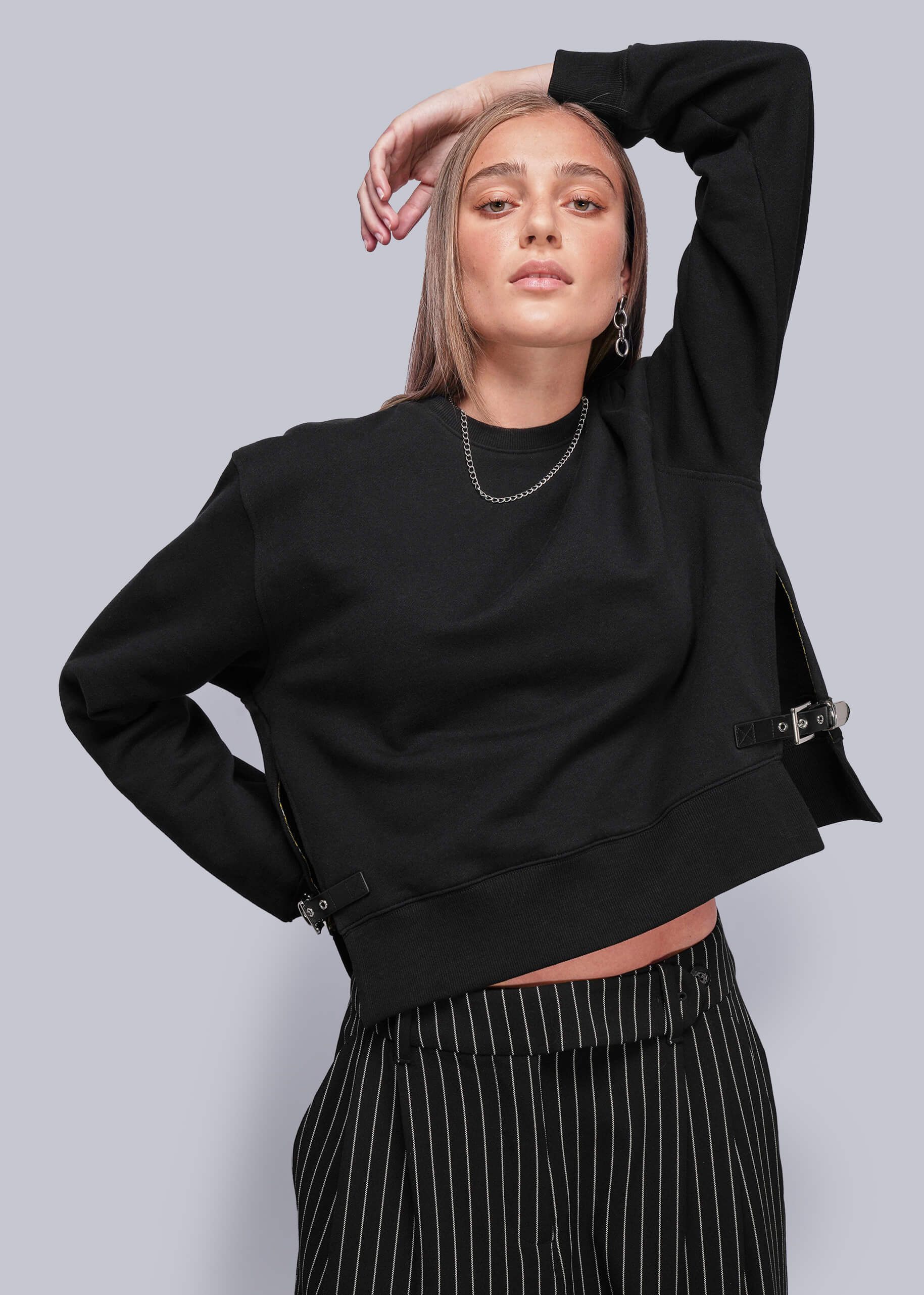 Person wearing a black sweatshirt with a plain background