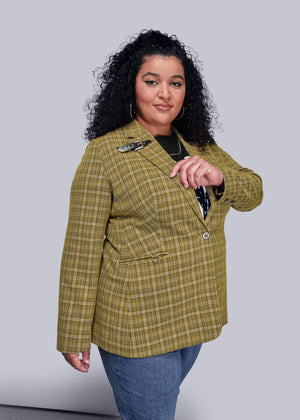 1X=Side view of person wearing a yellow plaid blazer against a gray background