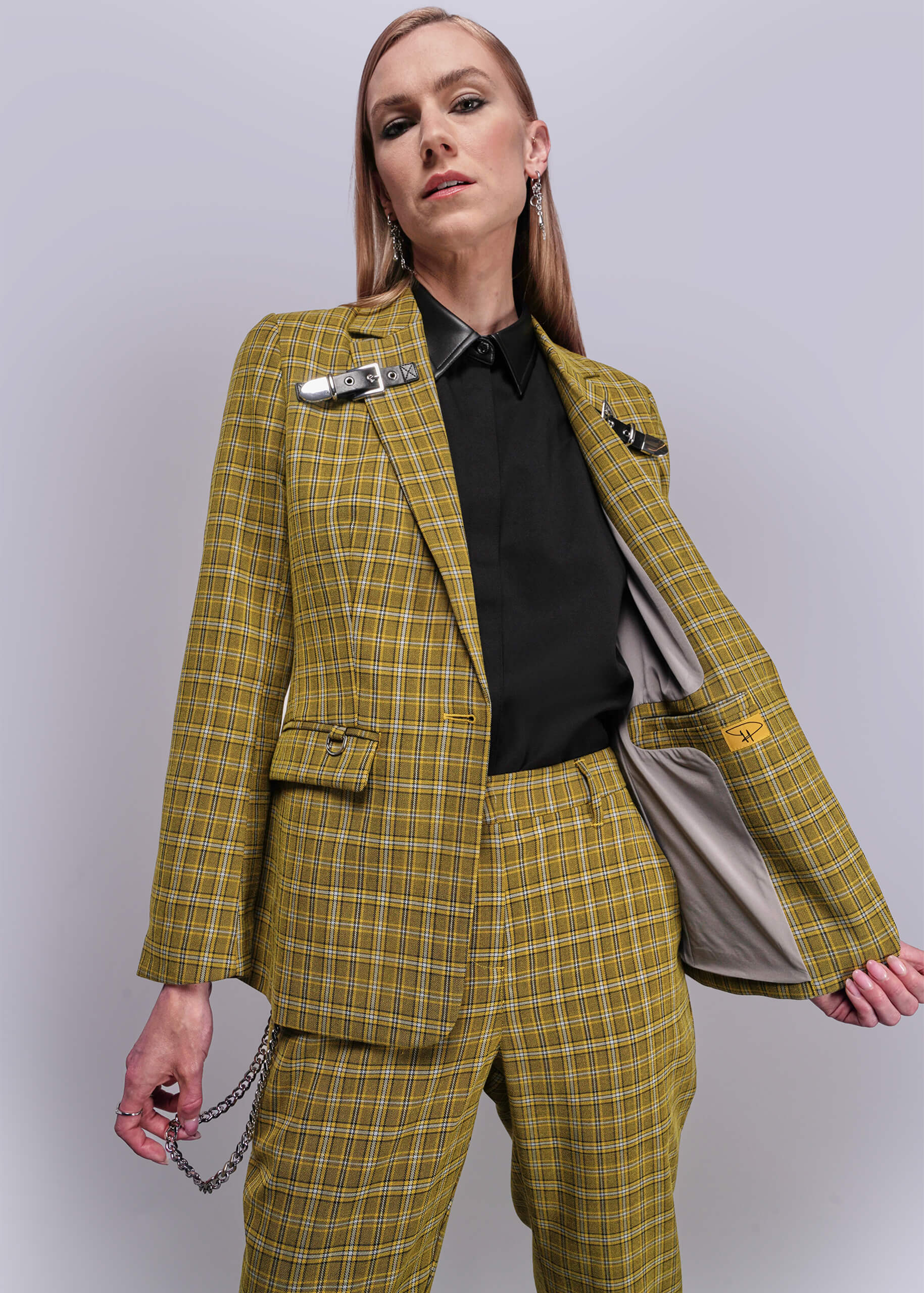 S=Person wearing a yellow plaid suit against a plain background