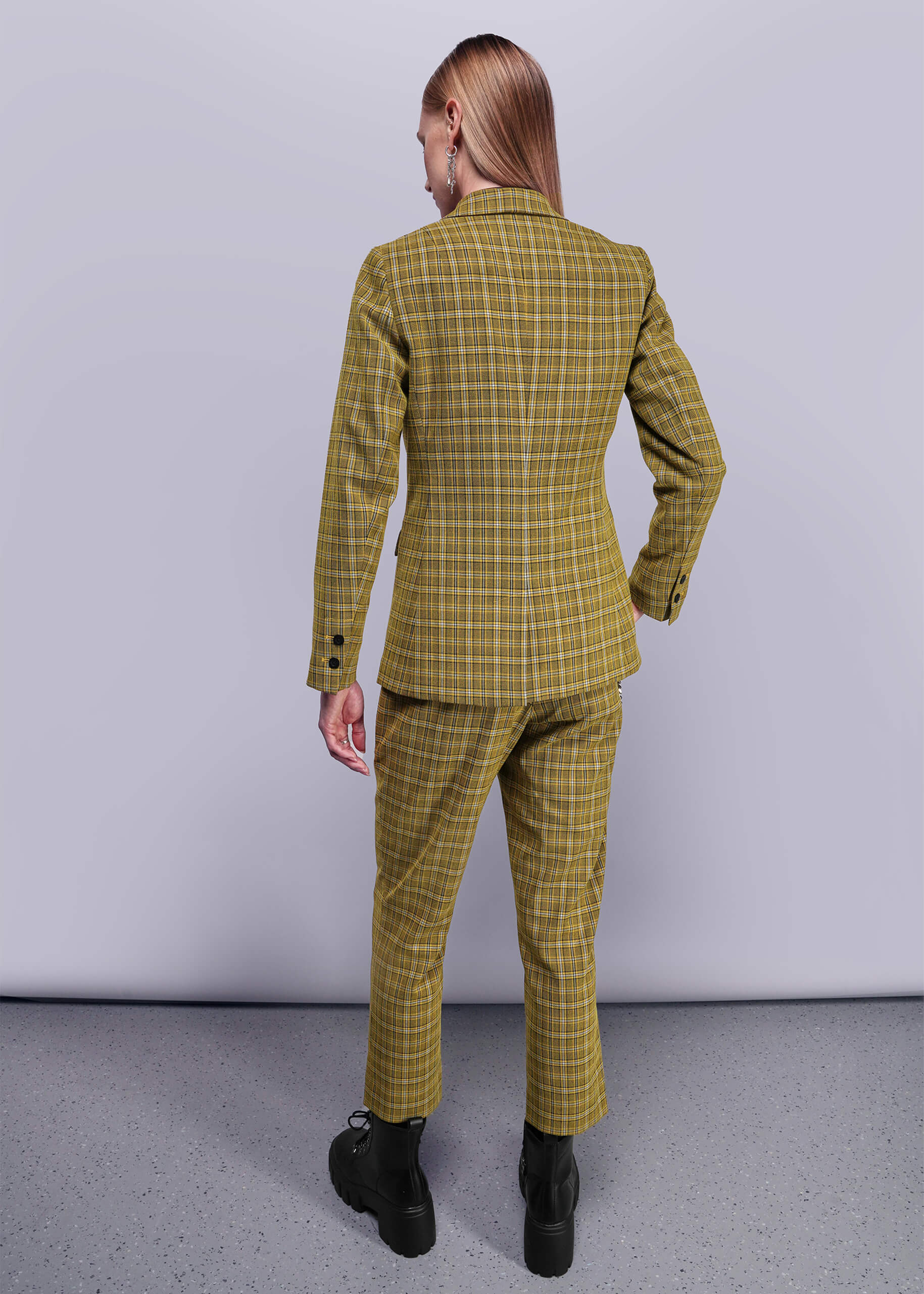 S=Back view of person wearing a yellow plaid suit against a plain background