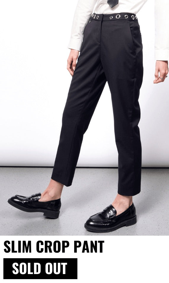 Model pictured from the waist down wearing the black Debbie Harry x Wildfang slim crop pant and black loafers. Text underneath image reads SLIM CROP PANT and button underneath reads SOLD OUT. White background.