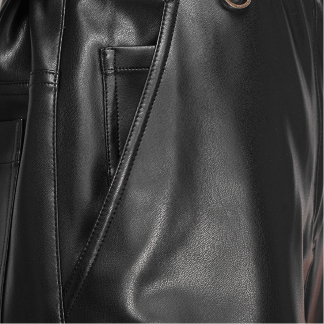 Person wearing a black leather coverall with a neutral background