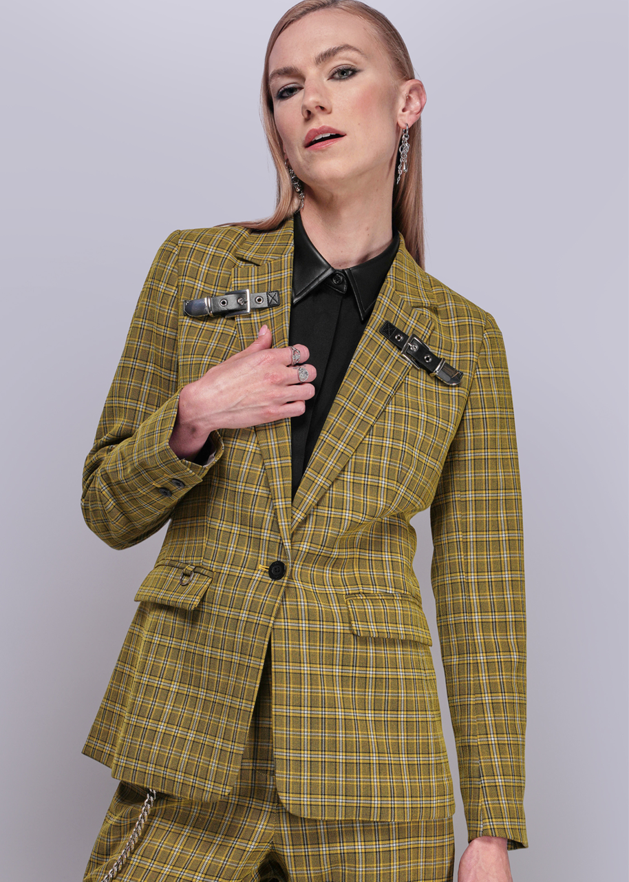 Woman wearing a yellow plaid suit against a plain background