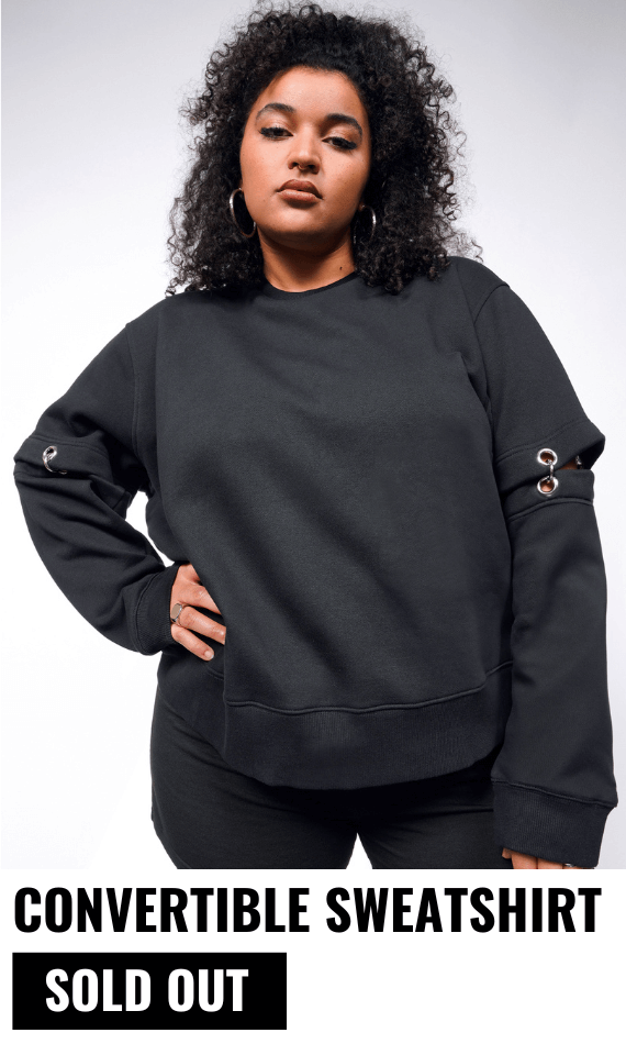 Person with black curly hair looks at camera and is wearing hoop earrings and the Debbie Harry x Wildfang Convertible Sweatshirt. Underneath text reads CONVERTIBLE SWEATSHIRT and button says SOLD OUT