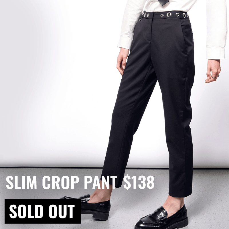 Model pictured from the waist down wearing the black Debbie Harry x Wildfang slim crop pant and black loafers. Text overlay on image reads SLIM CROP PANT $138 and button underneath reads SOLD OUT. White background.