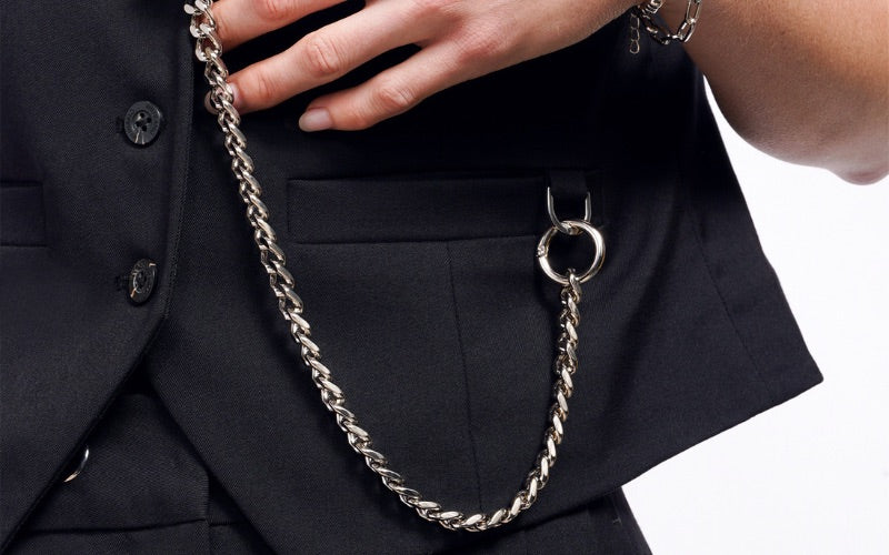Close up of Debbie Harry x Wildfang Vest showing silver chain connected to u link at pocket.