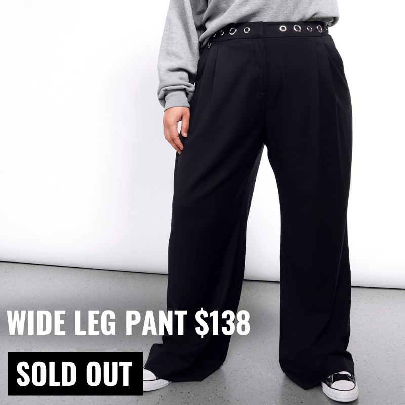 Image shows model from waist down wearing the Debbie Harry x Wildfang Wide Leg Pant in black and converse sneakers. Text overlay on image reads WIDE LEG PANT and button below reads SOLD OUT.