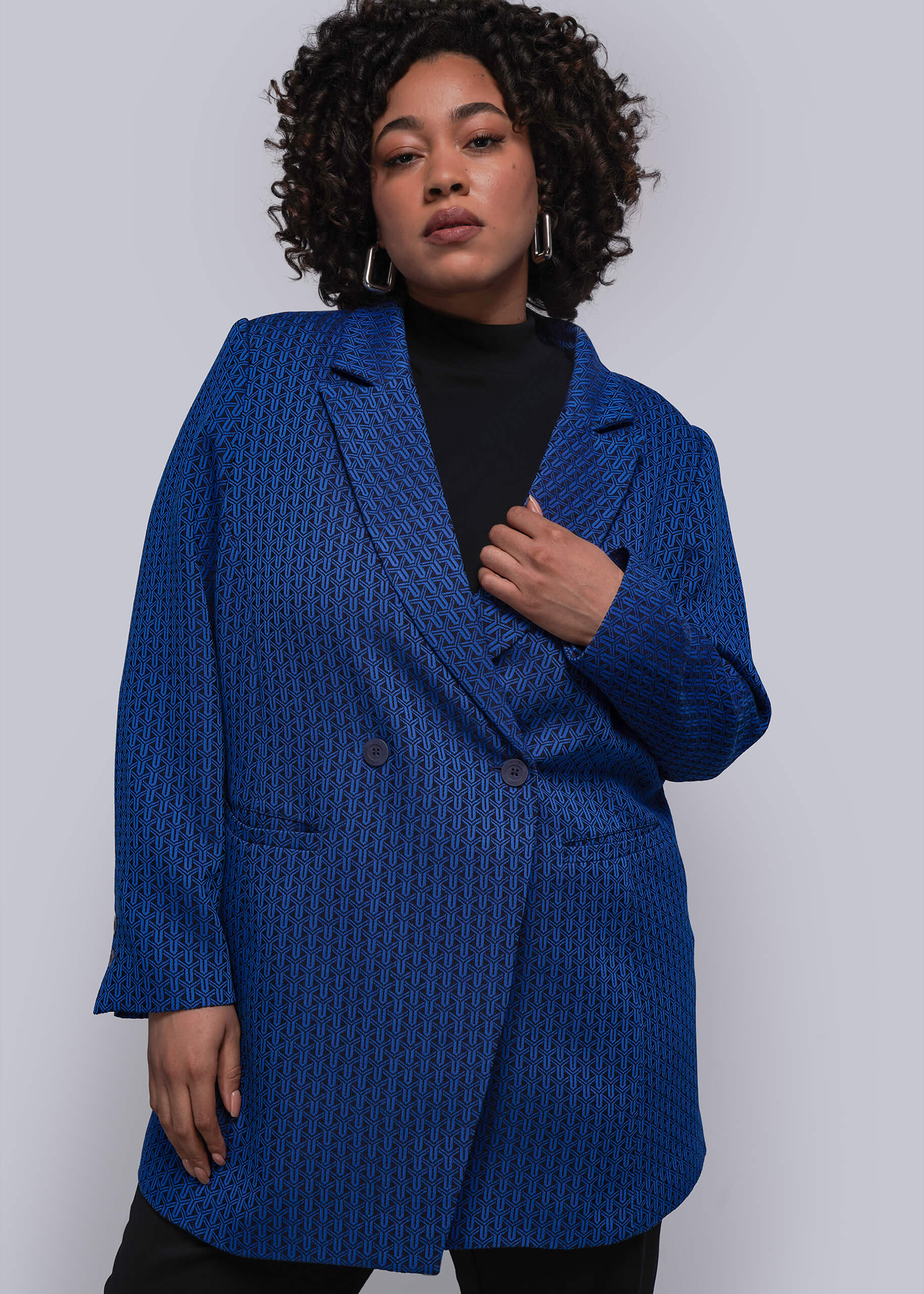 1X=Person wearing a blue textured blazer against a white background