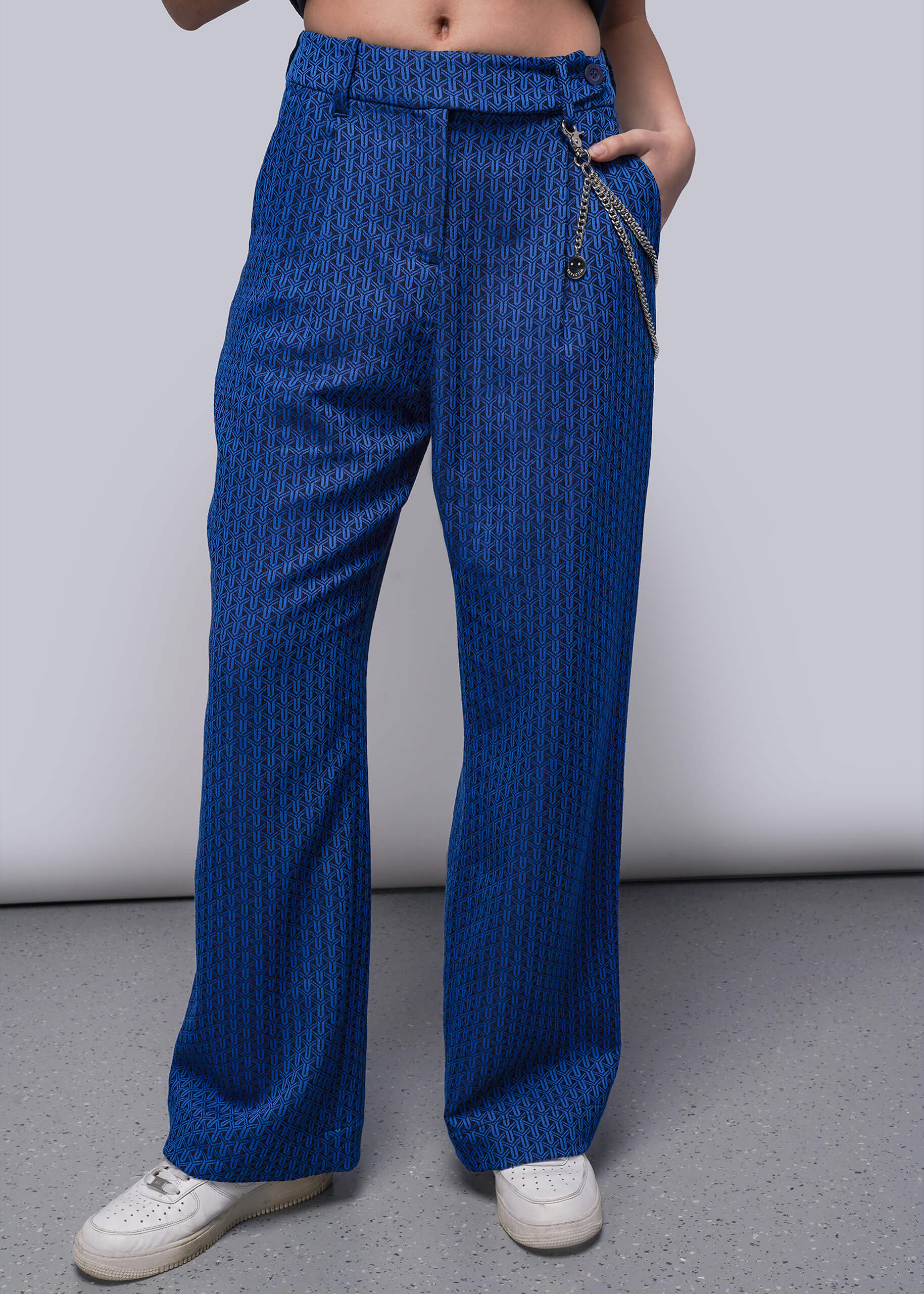 Person wearing blue patterned pants on a plain background