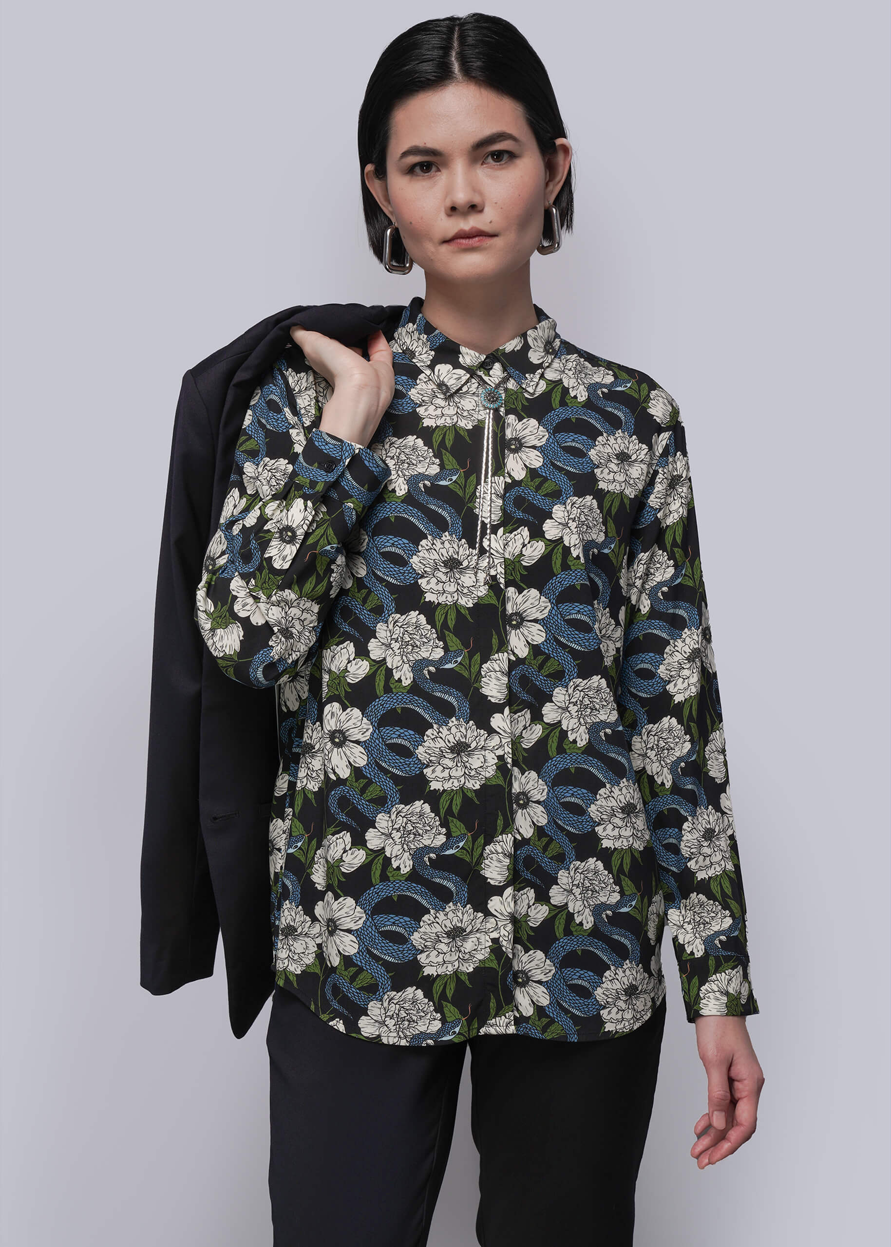 Person wearing a floral patterned shirt with a plain background