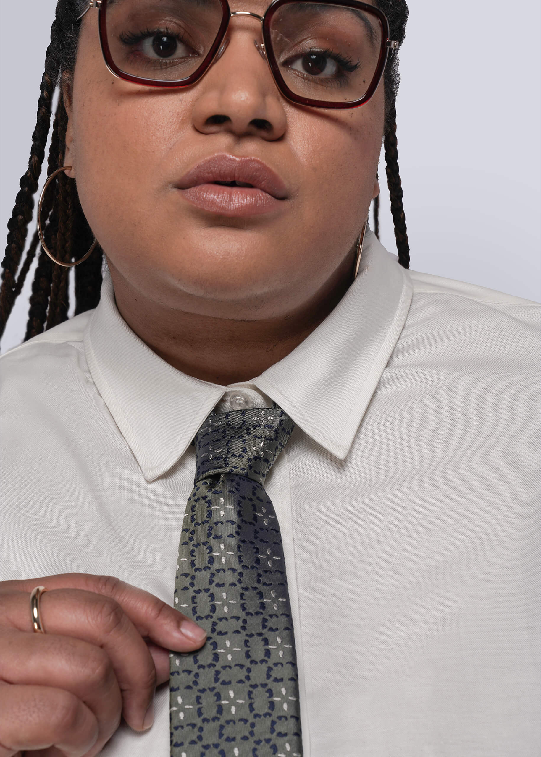 Person wearing a white shirt and patterned tie against a plain background
